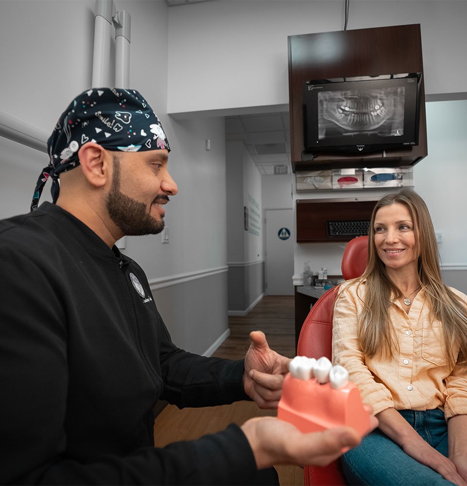 doctor going over dental consultation with implant model with patient