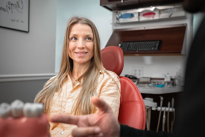 doctor showing patient single dental implant within the procedure room